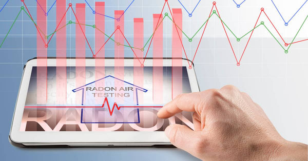 A hand presses the touchscreen of a tablet. The screen reads "Radon Air Testing" and shows data with line and bar graphs.