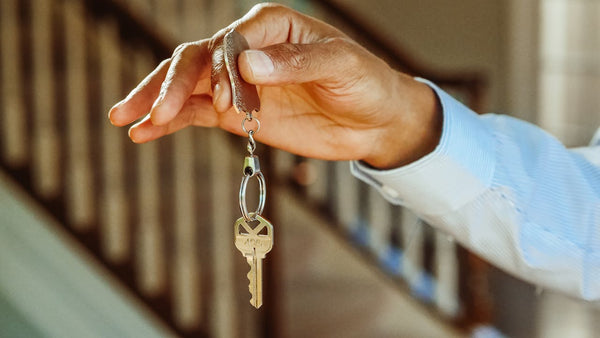 Person holding silver keychain with a key